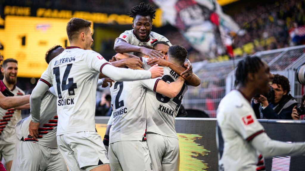 Edmond Tapsoba et les joueurs du Bayer Leverkusen célébrant après une égalisation à la dernière minute contre le Borussia Dortmund lors de la 30e journée du championnat.